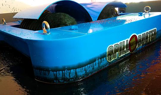 Turquoise Oil Skimmer working on the water surface - dual brush module recovering oil